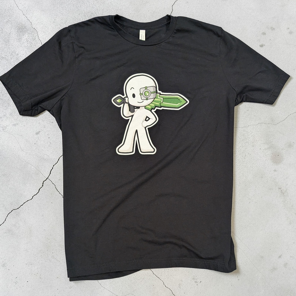 Black t-shirt with a white graphic design on a gray concrete surface