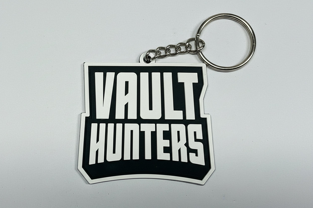 Two stickers on a metallic surface, one with a character design and the other with 'Vault Hunters' text.
